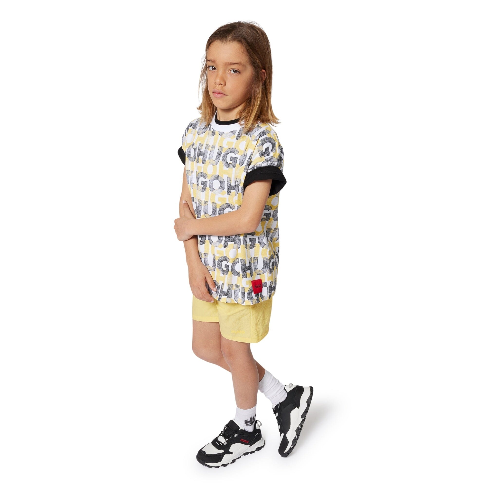 HUGO Kinder T-Shirt weiß Allover Logo Print in schwarz-gelb T-Shirt HUGO